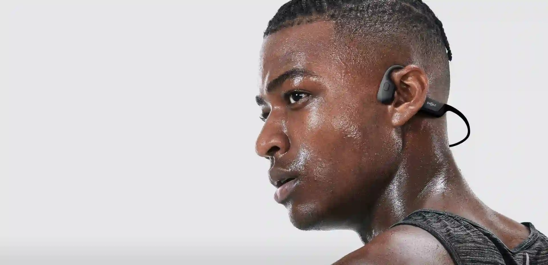 Sportif en sueur portant un casque à conduction osseuse Shokz noir autour de l'oreille